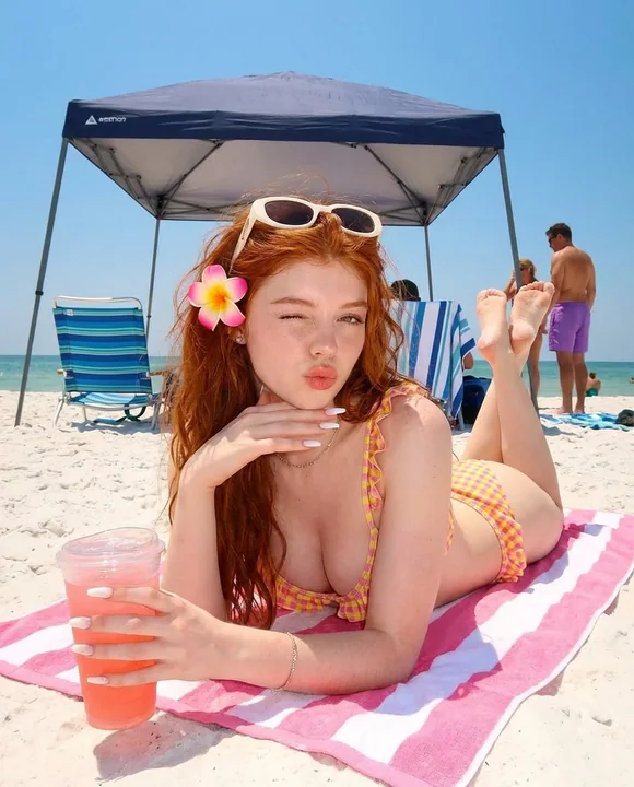 夏のビーチで赤い髪のセクシーなビキニ美女