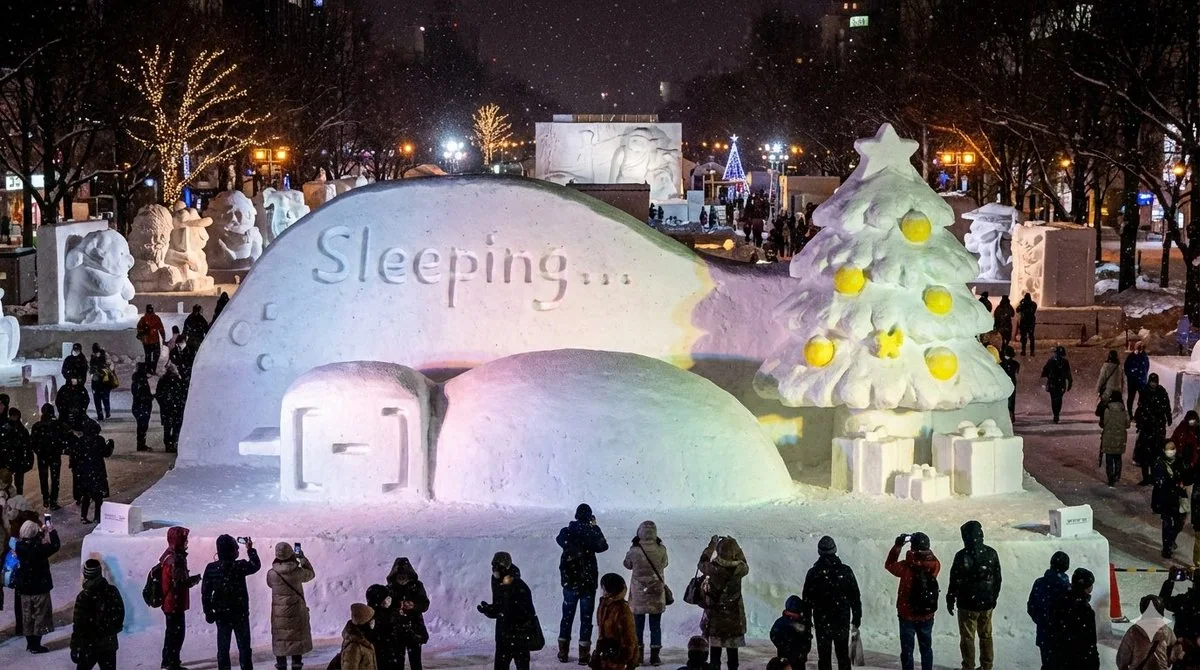 Statue de neige paresseuse pelotonnée dans un kotatsu