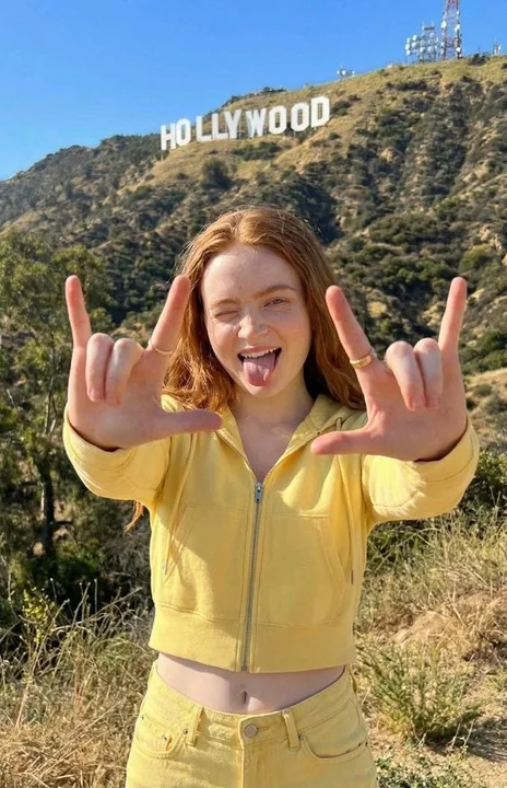 La jeune fille blonde espiègle devant la colline de Hollywood
