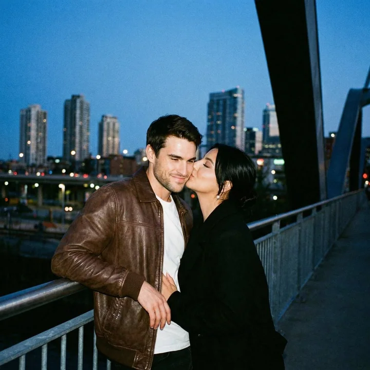 Film lovers kissing on the bridge under the bluesy night sky