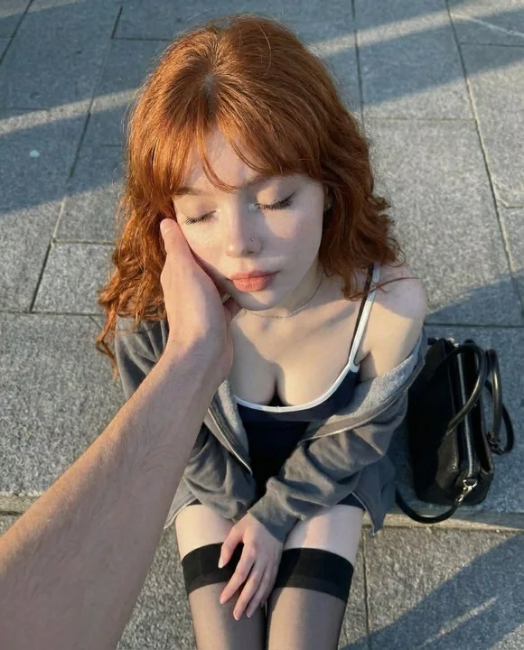 Red-haired girl in the golden hour street