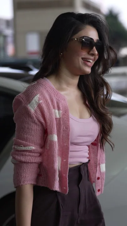 Femme élégante en tricot rose dans les rues de la ville