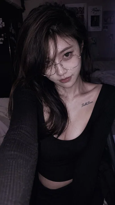 Autoportrait d'une célébrité chinoise en soirée dans une chambre d'hôtel, portant des lunettes en or fin