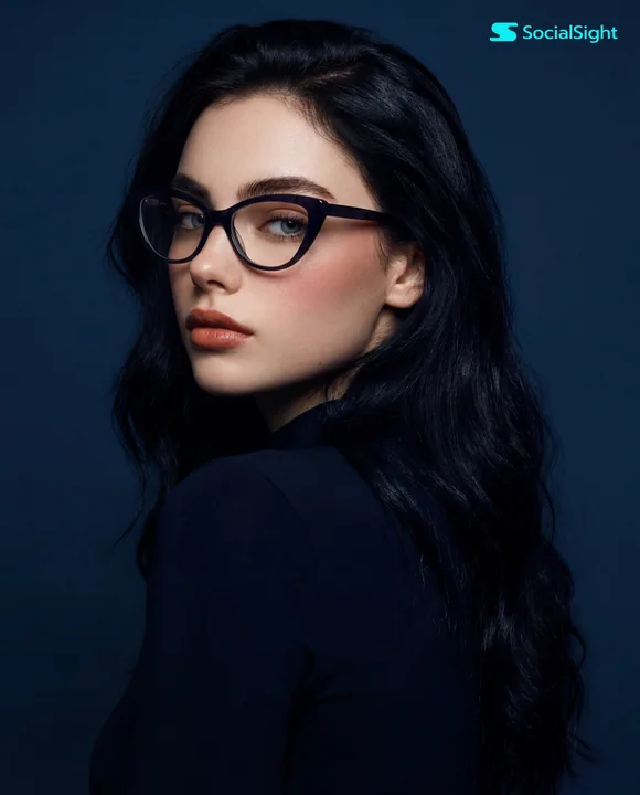 Photographie d’une jeune fille à lunettes, de profil, sur fond bleu, avec un regard en arrière plein de confiance