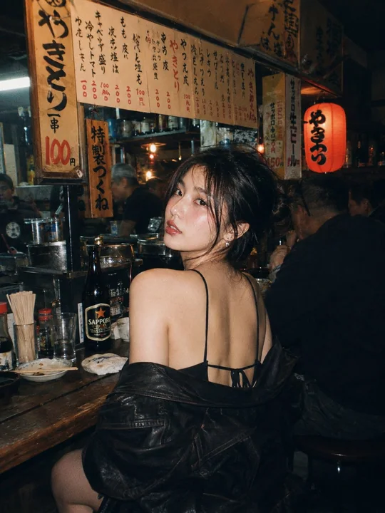 居酒屋で赤い服を着た東アジア美女の映画のような雰囲気の写真撮影