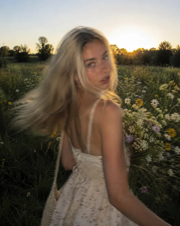 Portrait hyperréaliste dans une prairie de fleurs sauvages à l’heure dorée