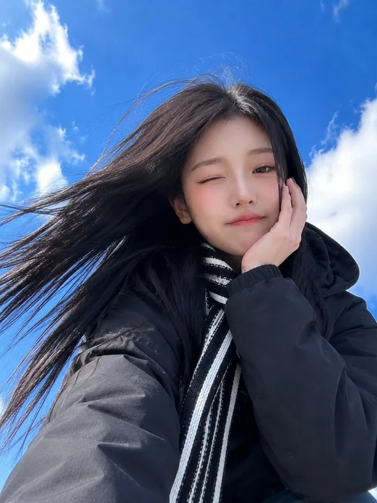 蓝天背景仰拍加油姿势东亚美女手机自拍