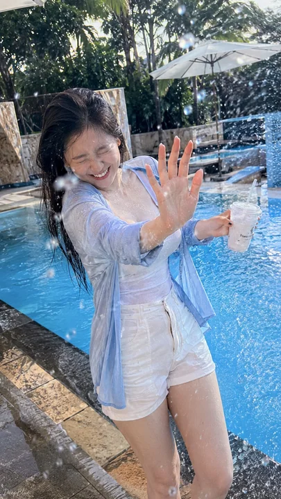 手机抓拍夏日泳池边丰满东亚女性水花溅起