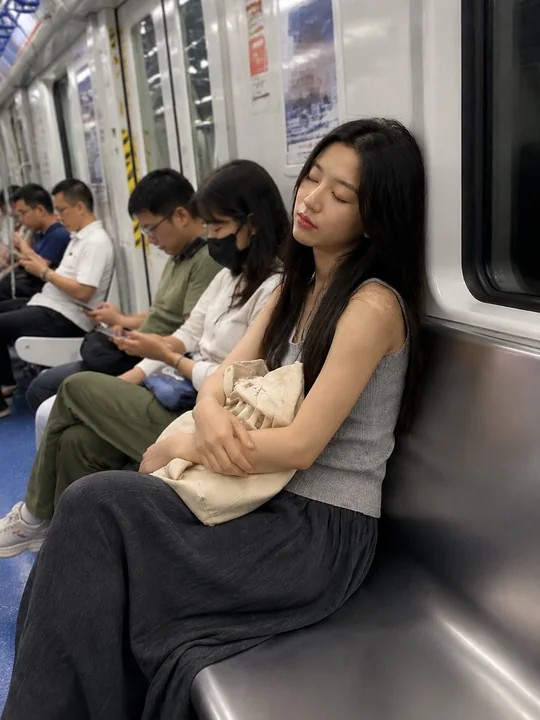 地铁早高峰通勤补觉的年轻女性