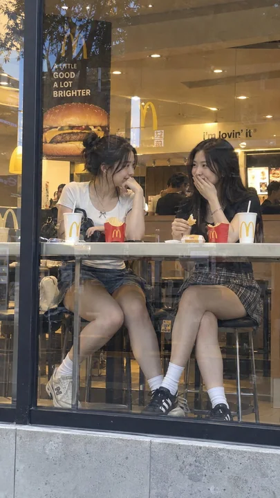 麦当劳窗边交谈的东亚女性街拍