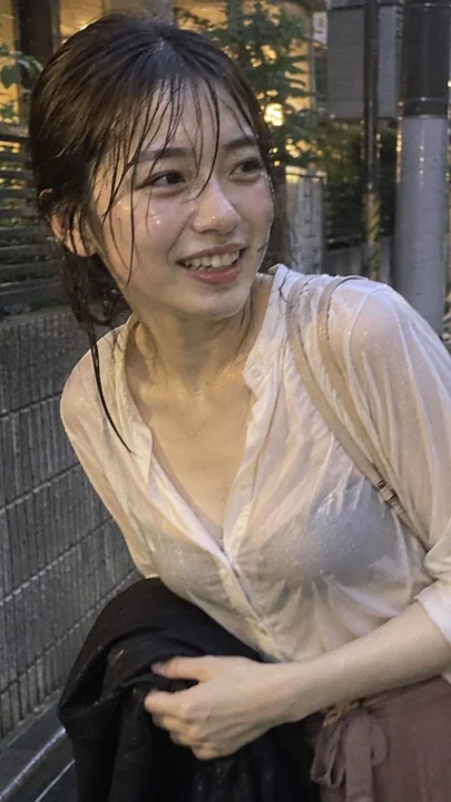 雨中街头抱衣侧笑的成年女性