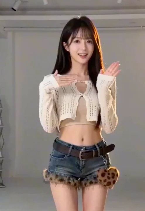 K-pop девочка в центре сцены, чистая и делающая знак сердца