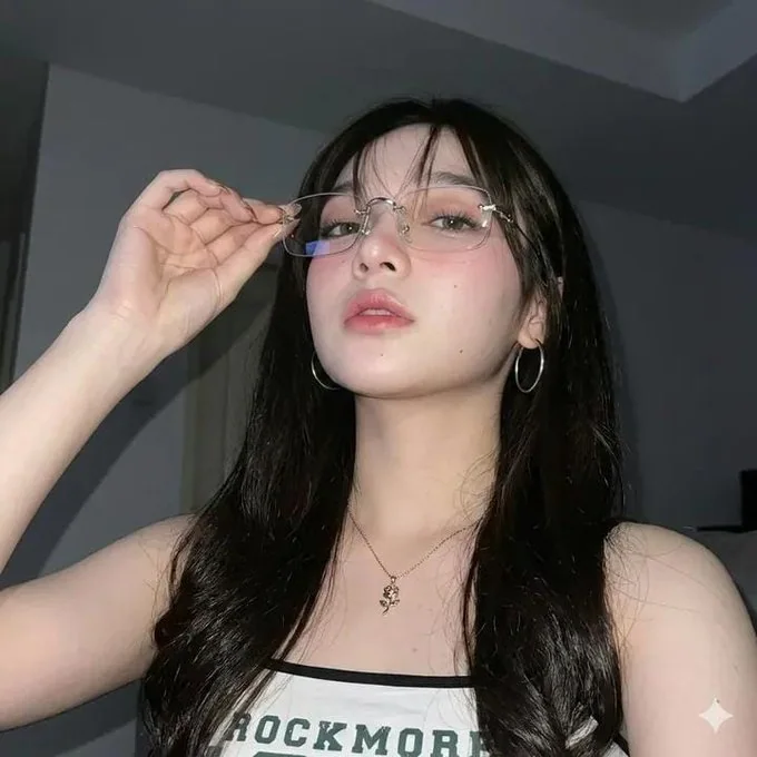 Look selfie nocturne : jeune fille en maquillage coréen léger et transparent, se mordant le doigt.