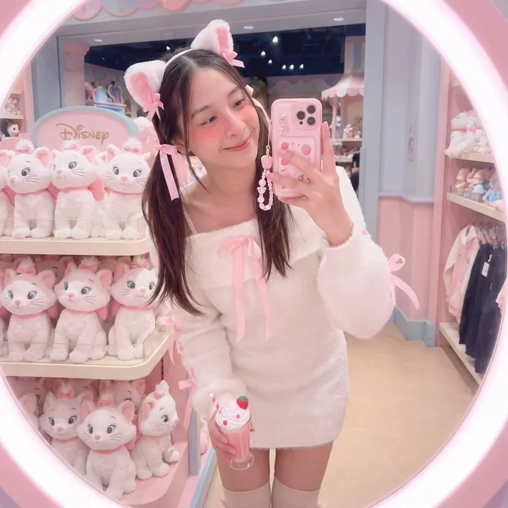 A woman is taking a selfie in front of a mirror at the Disney store.