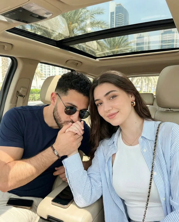 L'instant romantique d'un couple qui s'embrasse sur la main dans une voiture sous un doux soleil