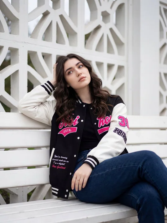 Jeune fille en style streetwear devant une grille géométrique blanche
