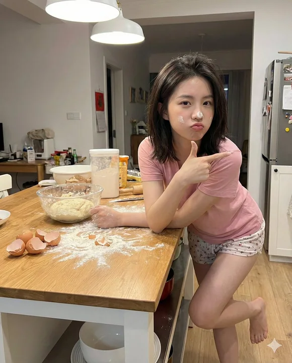 Une jeune fille rayonnante qui rit aux éclats, le visage couvert de farine, dans une cuisine en désordre