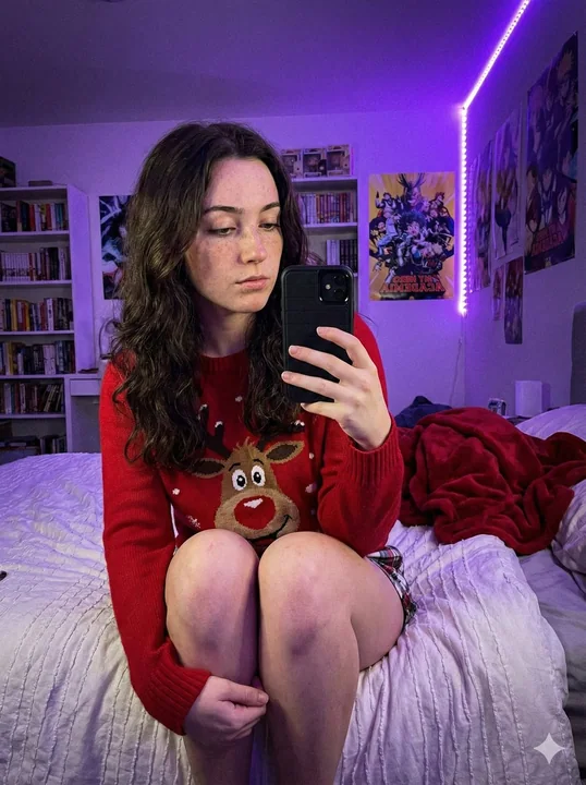 Selfie dans une chambre d’une fille portant un pull à renne sous une lumière d’ambiance violette