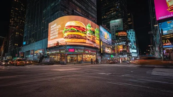 霓虹闪烁雨夜中的巨型美食广告牌