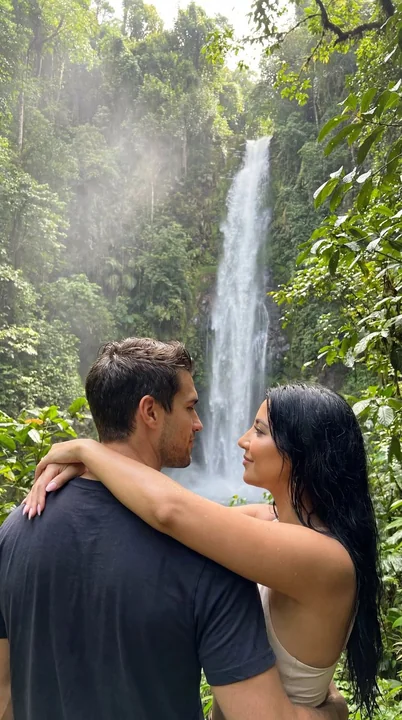 Couple enlacés passionnément dans une forêt tropicale hyper-réalisée, enveloppés dans la brume d'une cascade