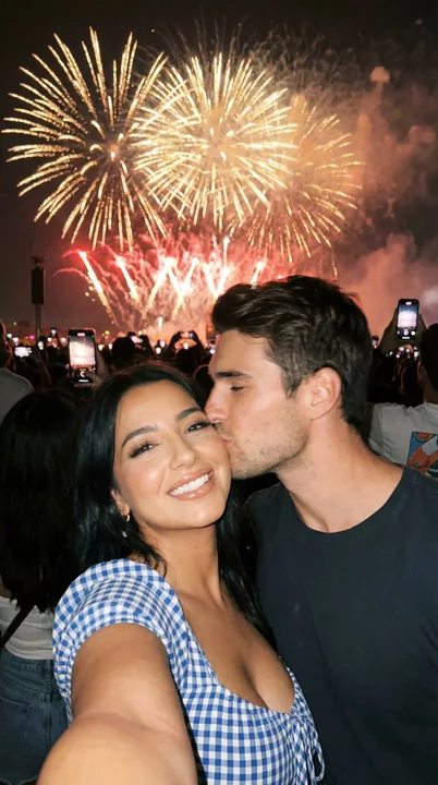 きらめく花火の下で親密にキスを交わすカップルの夜景セルフィー