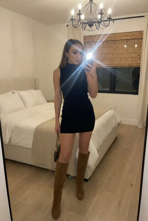 Selfie dans un miroir en pied d'une influenceuse mode dans une chambre moderne, sous le flash.